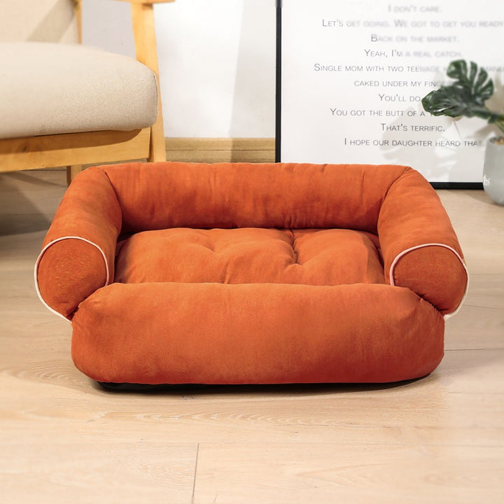 Hond ligt op een grijze pluche hondensofa