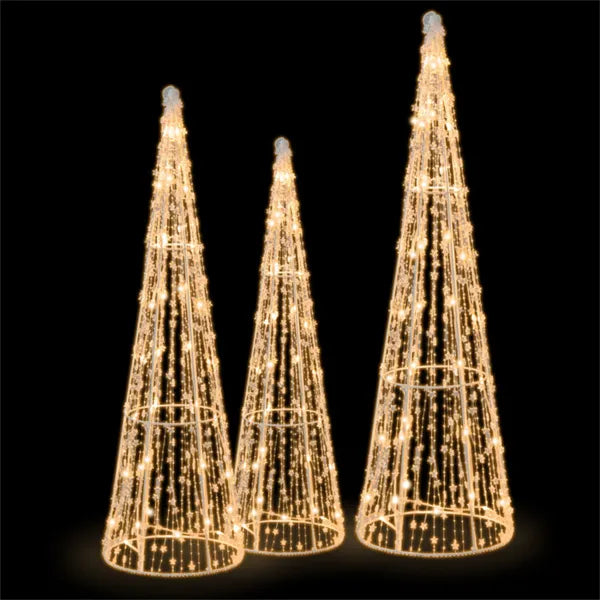 Drie verlichte kegelkerstbomen in de tuin