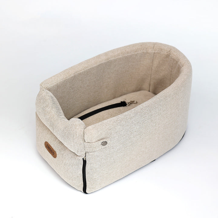 Kleine hond in een beige autostoeltje op de armleuning