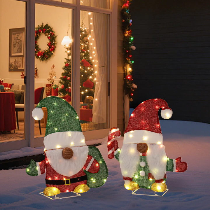 Twee verlichte kerstkabouters in de tuin