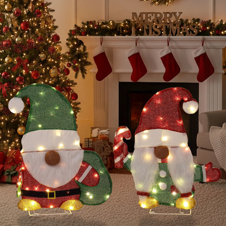 Twee verlichte kerstkabouters in de tuin