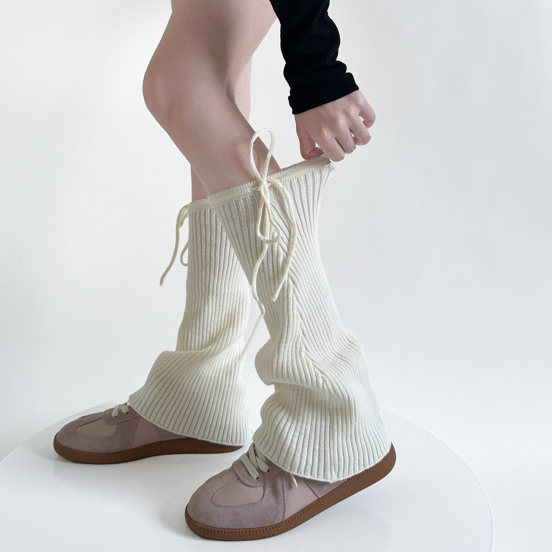 Geribde beenwarmers met strik over schoenen