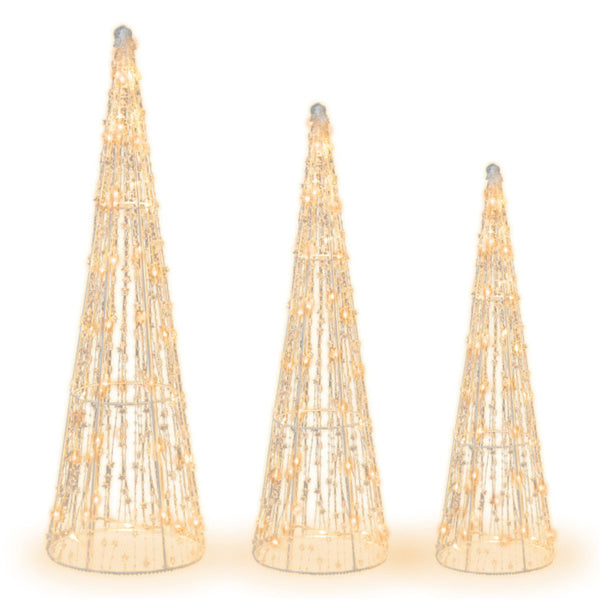 Drie verlichte kegelkerstbomen in de tuin