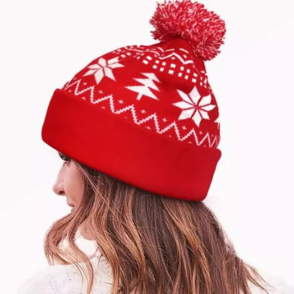 Gebreide kerstmuts met pompon en sneeuwvlokken