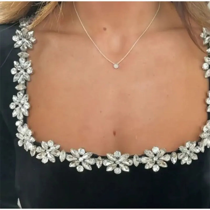 Vrouw in minijurk met strass-bloemen bij hals