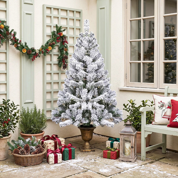 Kleine besneeuwde kerstboom in pot