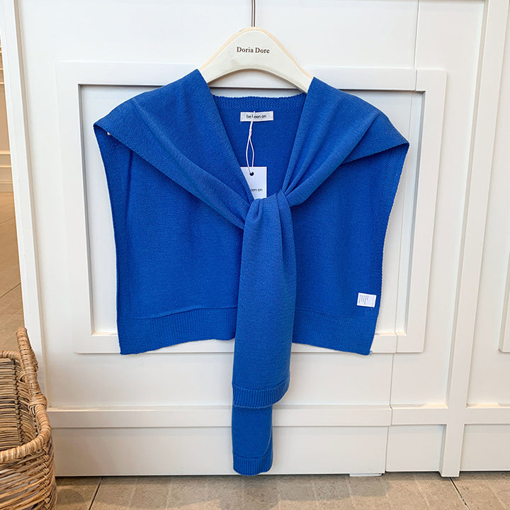 Vrouw met gebreide schouderdoek gestrikt