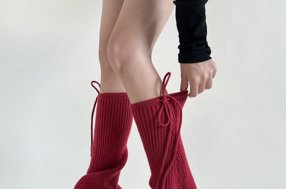 Geribde beenwarmers met strik over schoenen