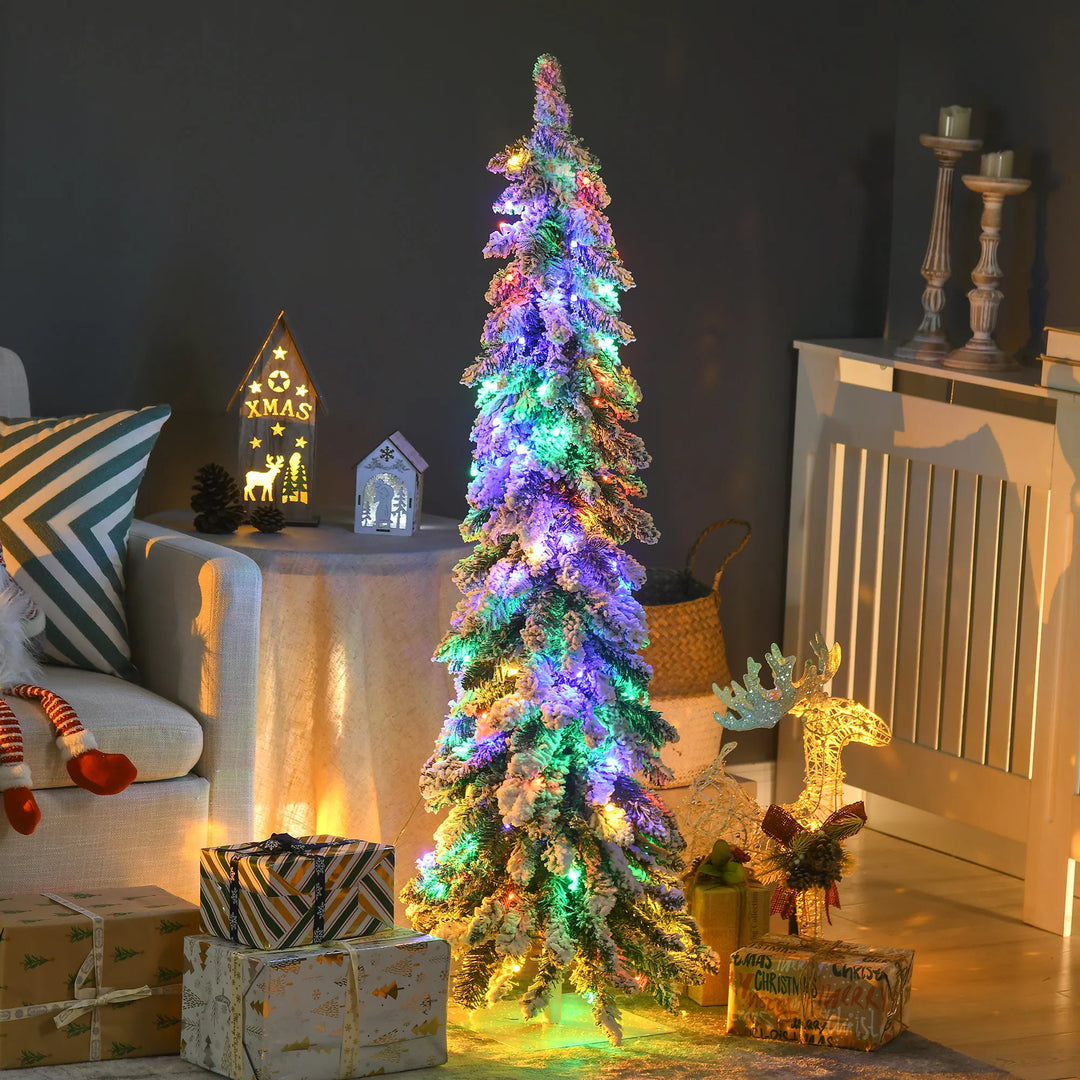 Kleine smalle besneeuwde kerstboom met lichtjes