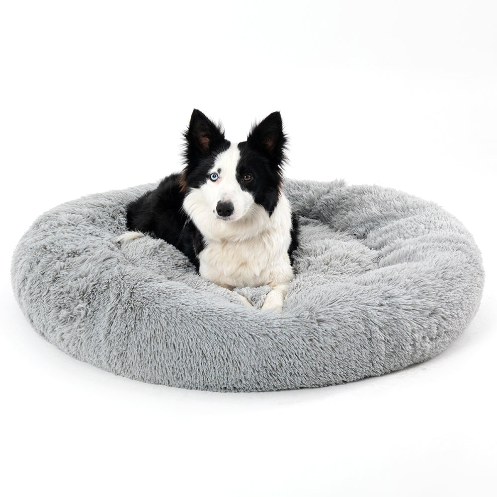 Hond ligt opgerold in een grijze donutmand