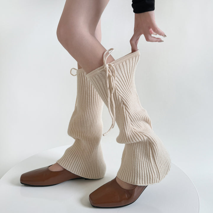 Geribde beenwarmers met strik over schoenen