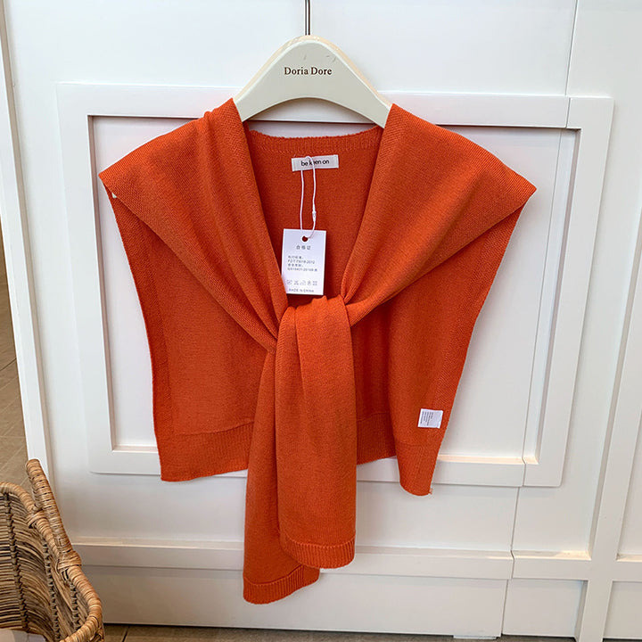 Vrouw met gebreide schouderdoek gestrikt