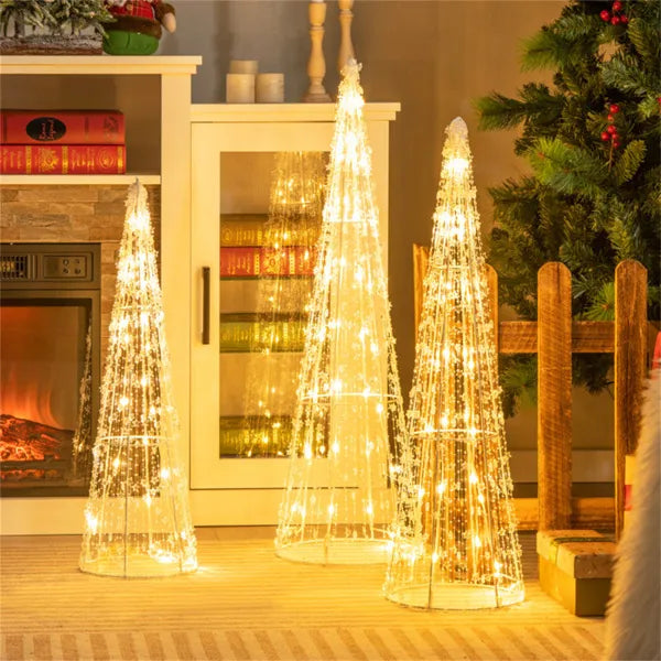 Drie verlichte kegelkerstbomen in de tuin