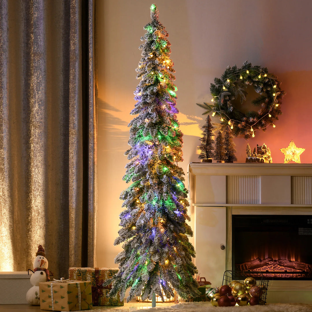 Smalle besneeuwde kerstboom met kleurlichtjes