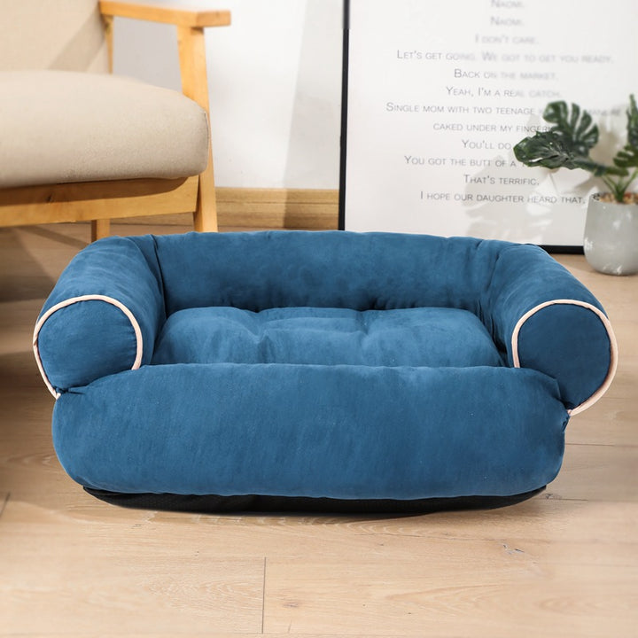 Hond ligt op een grijze pluche hondensofa