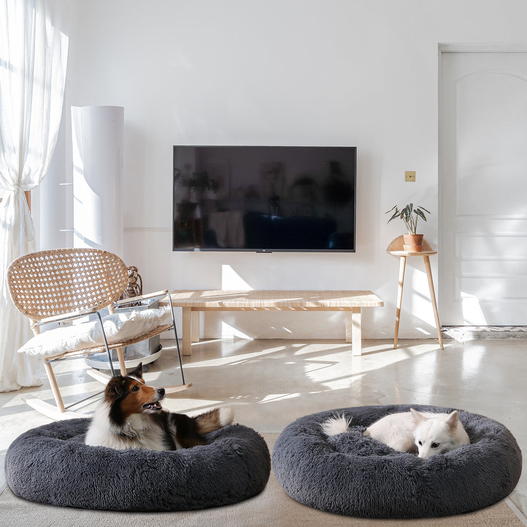 Hond ligt opgerold in een grijze donutmand