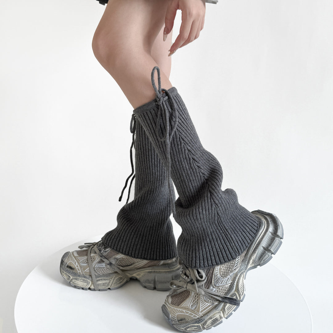 Geribde beenwarmers met strik over schoenen